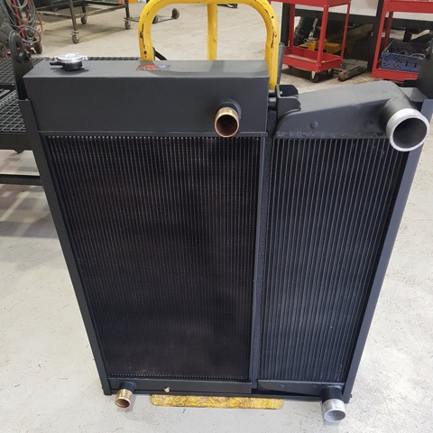 A large twin-core plant radiator finished in black, standing in the workshop
