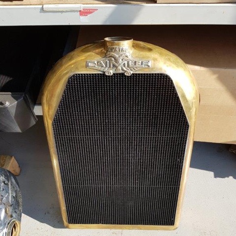 A vintage radiator with a polished brass shell, crest and honeycomb core