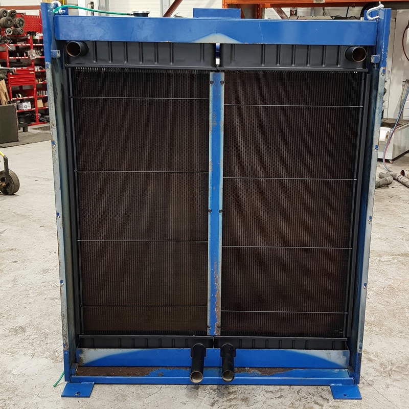 A large twin-core plant radiator in a blue steel frame, standing on the workshop floor