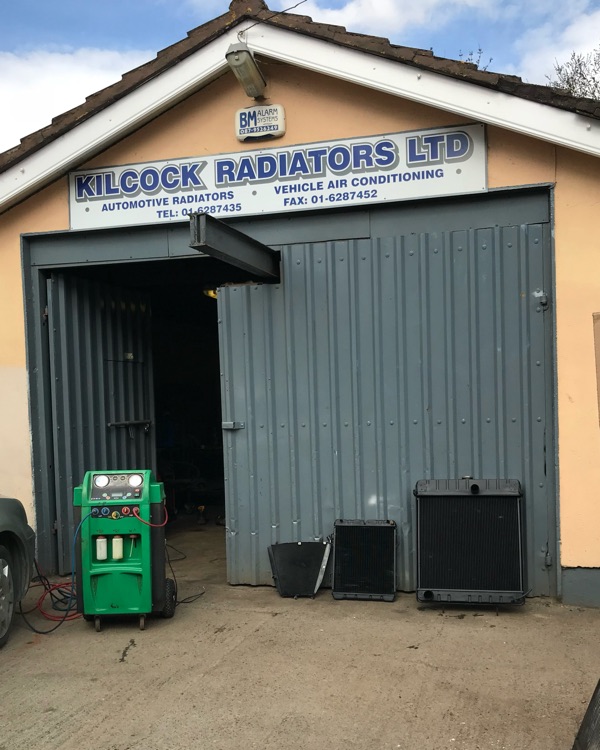 The old Kilcock Radiators Ltd workshop: a painted gable with a sign reading Automotive Radiators and Vehicle Air Conditioning, radiators stacked by the open door
